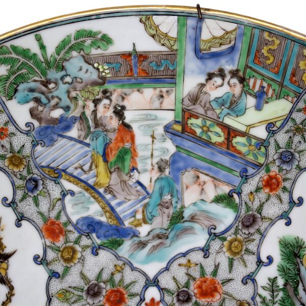 A close up of a Chinese porcelain famille rose charger to obtain its condition and quality.